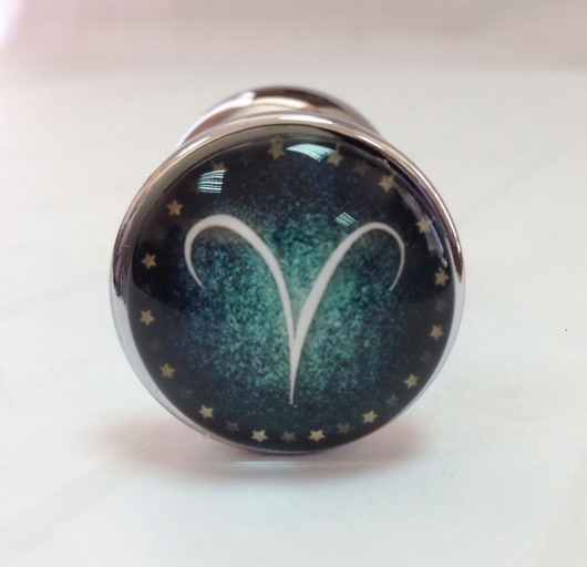 Серебристая анальная пробка с зеленым кристаллом и знаком зодиака - Овен - Главсексмаг - купить с доставкой в Москве