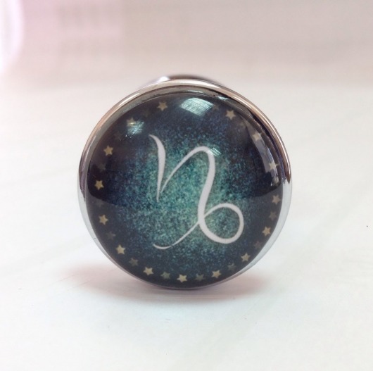 Серебристая анальная пробка с зеленым кристаллом и знаком зодиака - Козерог - Главсексмаг - купить с доставкой в Москве